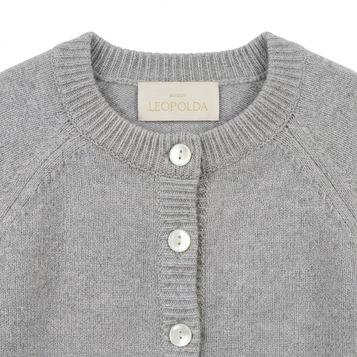 Detail of Maison Leopolda Cleo grey cashmere baby cardigan showing mother-of-pearl buttons